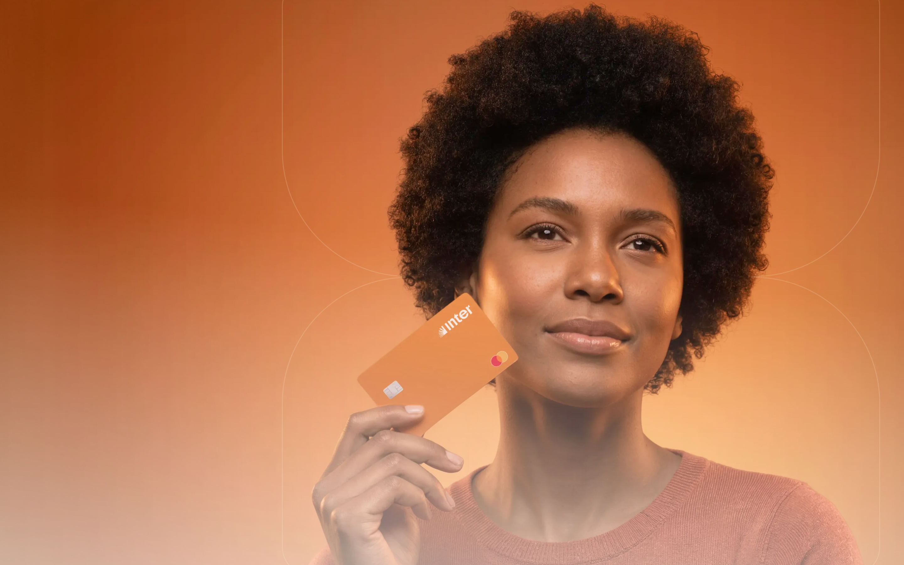 Mulher sorrindo segurando um cartão do Banco Inter